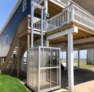 Modern home elevator installed beside a raised wooden deck, enhancing accessibility to the upper level of the house.