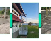 Home elevator installation by the seaside, showing concrete base, elevator structure on the house, and framed dirt foundation.
